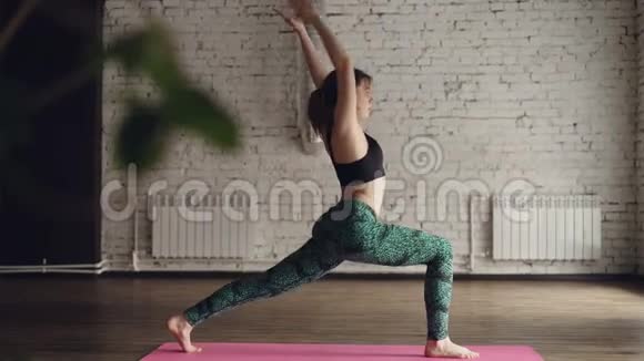 时尚运动服装的年轻女性正在现代健康中心的个人练习中练习瑜伽她在做视频的预览图