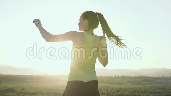 一个年轻漂亮的拳击手女子训练打击它是在山景的背景上的表面视频的预览图