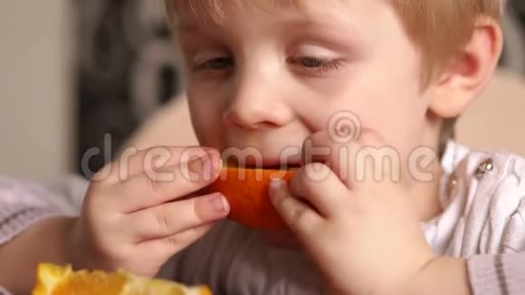 小男孩高兴地吃橘子特写视频的预览图