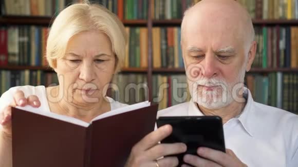 高年级夫妇在家读e书和实物打印书纸张与数字阅读的概念视频的预览图