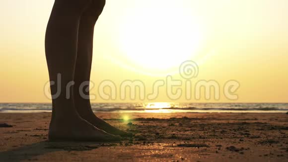 日落时分母亲和女儿在海滩上做体操的剪影视频的预览图