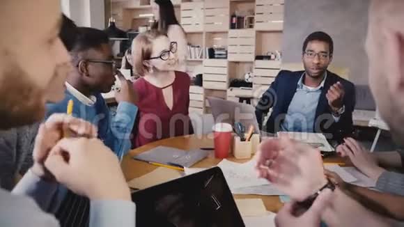 混合种族团队在办公室会议上集思广益快乐创意千禧同事小组讨论商业创意4K视频的预览图
