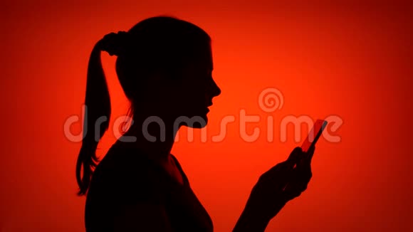 女性在红色背景下使用手机的剪影女的侧脸收到好消息视频的预览图