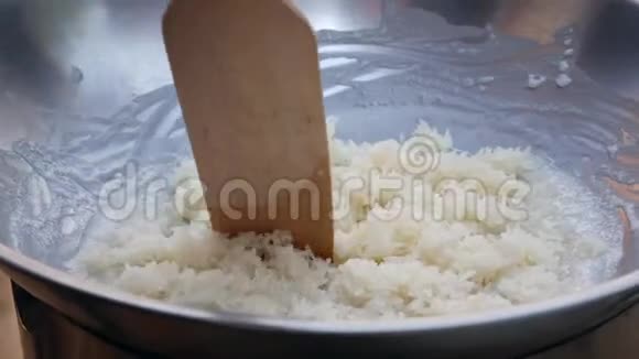 男人用椰奶在炒锅里搅拌米饭一步步烹制泰国糯米泰国菜特写镜头4k视频的预览图