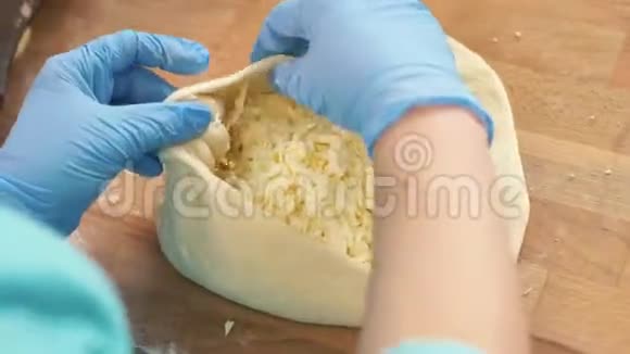厨师面包师在烘焙前用面团和奶酪做馅饼视频的预览图
