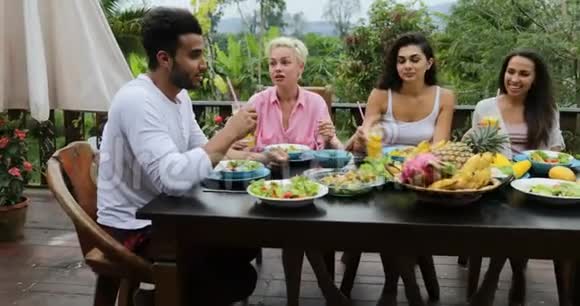 吃健康素食食品的人小组夹汁酒杯热带餐桌上的朋友交流视频的预览图