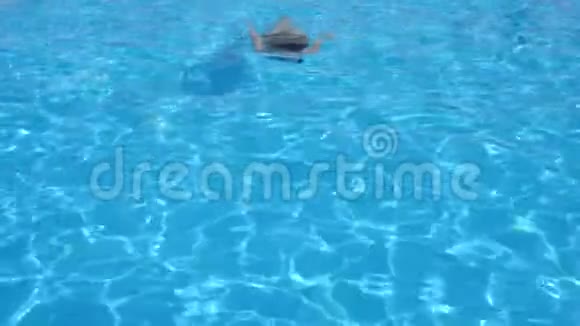 穿着泳衣的女孩慢动作在蓝水下游泳然后从游泳池里出来视频的预览图