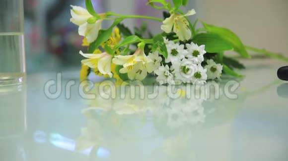 玻璃桌上摆着高清嫩白黄的花朵视频的预览图