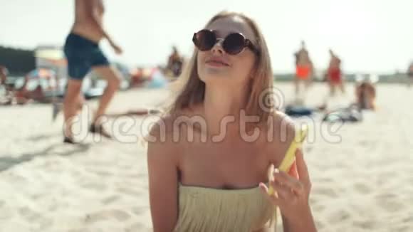 穿比基尼的美女在海滩上打电话视频的预览图