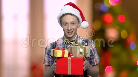 戴圣诞帽的男孩送礼物盒视频的预览图