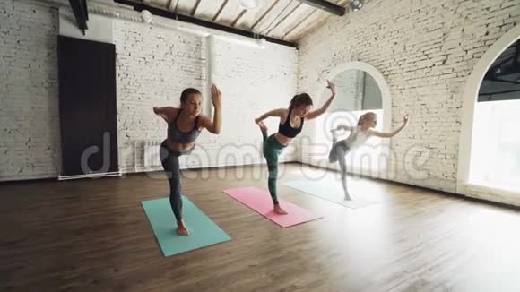 多莉拍摄的瑜伽学生做主舞姿势赤脚站在五颜六色的垫子上女人穿着时髦视频的预览图