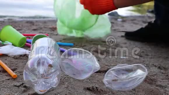 海滩上的垃圾收集塑料和包裹散落在海滩上一个人收集塑料生态保护概念视频的预览图