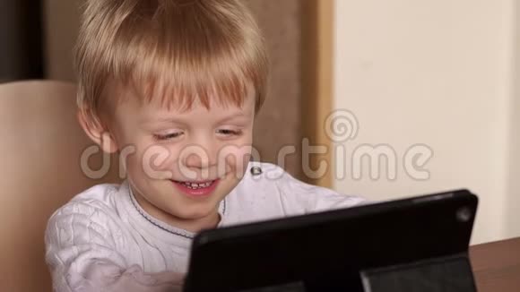 小男孩在平板上看动画片笑了视频的预览图
