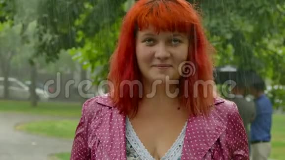 红发女孩在雨中变得湿漉漉的视频的预览图