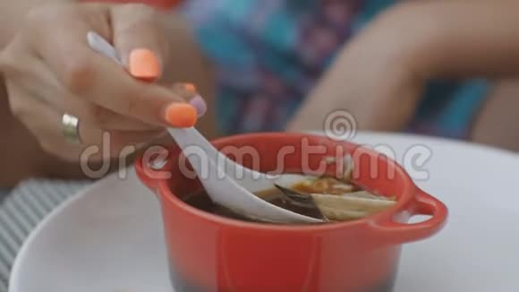 在日本餐馆的露天平台上一位年轻的白种人正在和软体动物一起吃汤视频的预览图