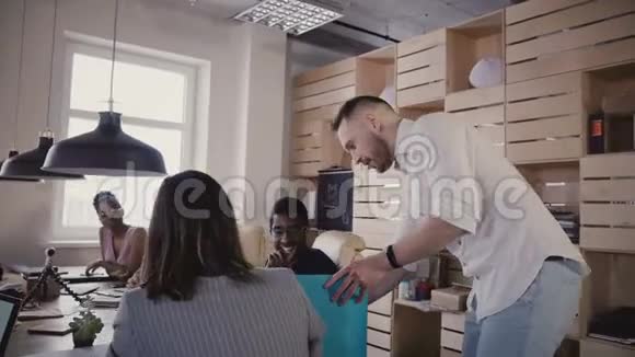 镜头跟随男组长与同事交谈在气垫板上退出办公室快乐商人在室内使用Segway视频的预览图