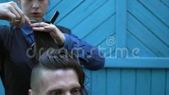 夏季户外理发店一位美丽的女理发师在实验中剪下了奇怪的中年嬉皮士的头发视频的预览图