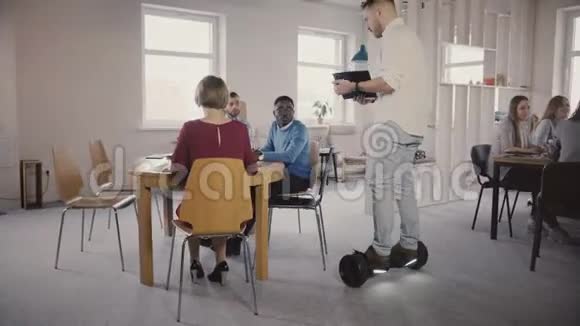 年轻的男老板用气垫板来和同事交谈自信的领导者在现代办公4K中使用技术视频的预览图