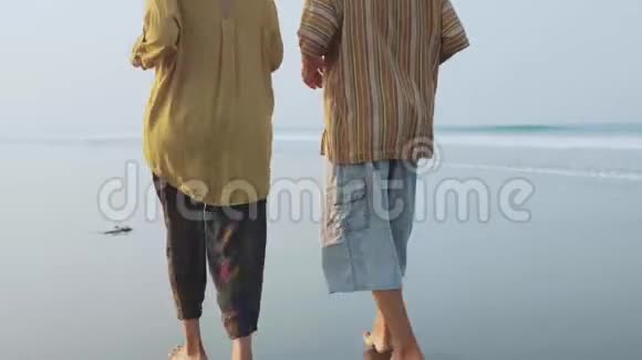 在日出时在沙滩上奔跑的老夫妇视频的预览图