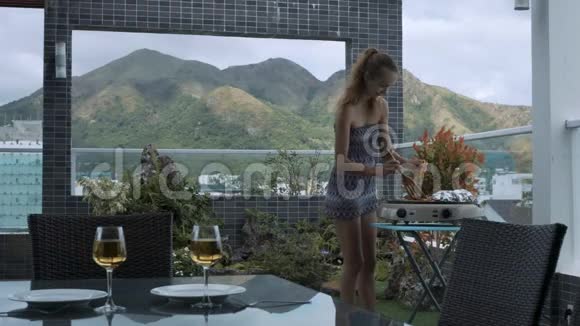 女孩用酒杯在上面的露台上做饭视频的预览图