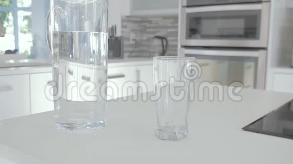 把水罐里的水倒进玻璃杯的人视频的预览图