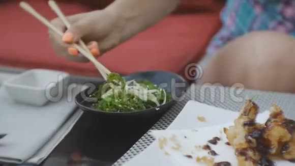 尝试日本料理的女人一位迷人的年轻白种人女士用海草沙拉做的特写视频的预览图