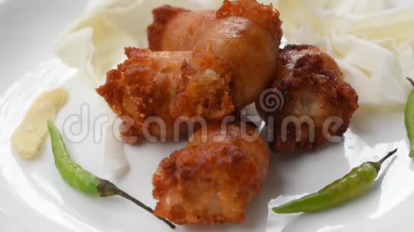炸酸泰国香肠肉馅猪肉和玻璃面被银叉刺在盘子里吃视频的预览图