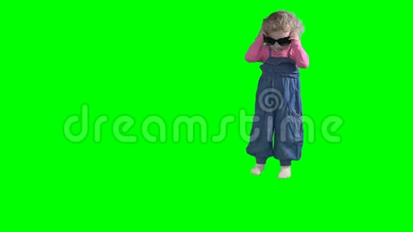 快乐的小孩把妈妈的太阳镜戴在头上把微笑隔离在绿色上视频的预览图