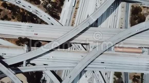 俯视图无人驾驶飞机在高速公路立交桥上方快速旋转汽车在多个天桥道路和桥梁上行驶视频的预览图