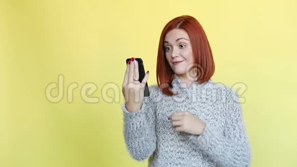 穿着舒适的灰色毛衣的感情红发女人在打电话视频的预览图