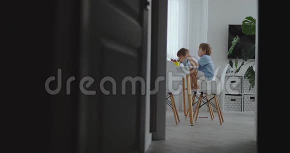 幸福的家庭年轻美丽的母亲和两个儿子用彩色铅笔在厨房的桌子旁画画这就是视频的预览图