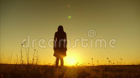 自由而快乐的长发女孩在金色的太阳日落时跳跃慢动作视频的预览图