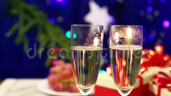 在有礼物的桌子上有两个带香槟的酒杯放在她祖国的新年背景上视频的预览图
