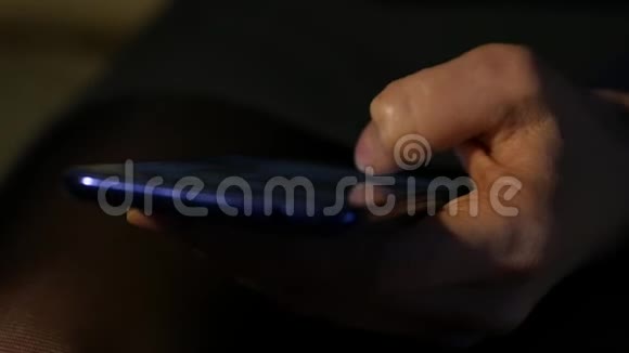 关闭女性她的手指在夜间使用智能手机女孩在手机上浏览互联网视频的预览图