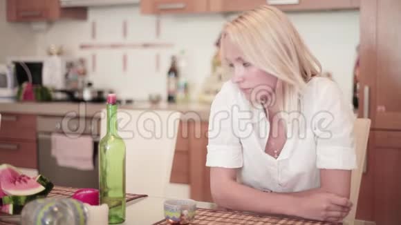 年轻男子加入她的公司时微笑的金发女孩坐在厨房的桌子上视频的预览图