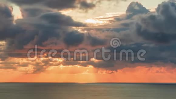 日落时天空中的云层越过海平面阳光透过风暴的云层出现视频的预览图