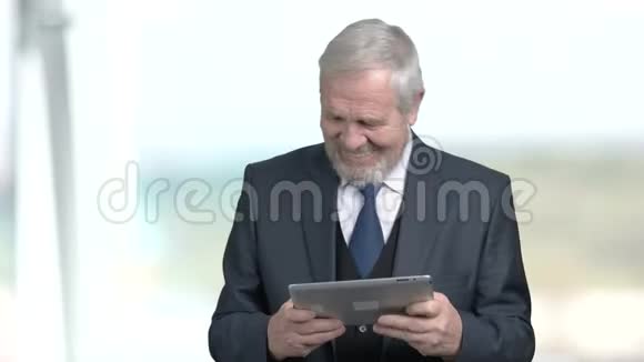 老商人玩电脑平板电脑视频的预览图