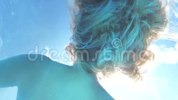 女孩白皙的头发在水中游动阳光透过头发闪闪发光视频的预览图