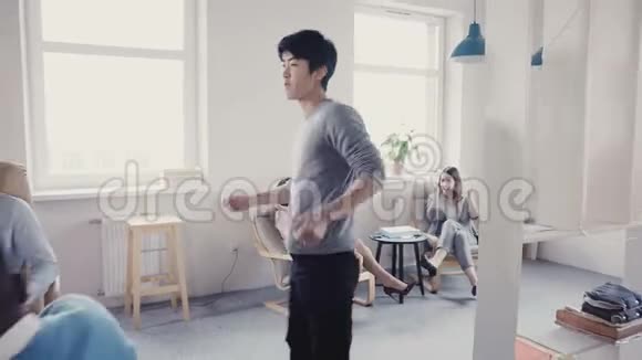 快乐亚洲经理在现代办公室做非常有趣的庆祝舞蹈行走多民族同事鼓掌笑4K视频的预览图