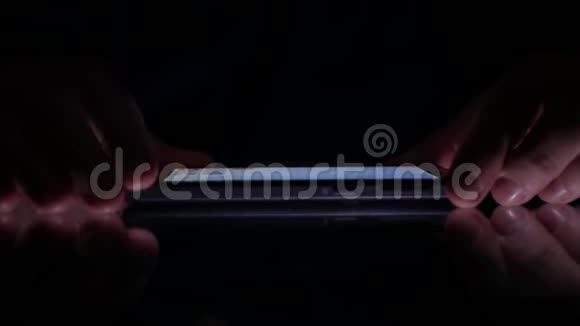 在黑暗中使用手机特写商人手短信视频的预览图