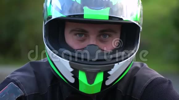 一个骑摩托车的人带着摩托车在山上的年轻帅哥他在看摄像机关闭视频的预览图