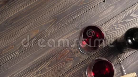 豪华红酒两杯葡萄酒杯由美味的红葡萄制成一个开瓶器和一个酒瓶子放在桌子上视频的预览图