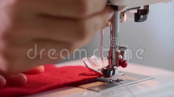女裁缝的手在缝纫机上缝红色衣服上的直缝视频的预览图