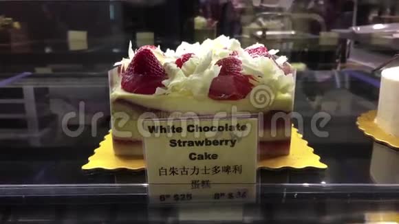 陈列架上白巧克力草莓蛋糕的运动视频的预览图