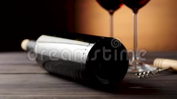 豪华红酒两杯葡萄酒杯由美味的红葡萄制成一个开瓶器和一个酒瓶子放在桌子上视频的预览图