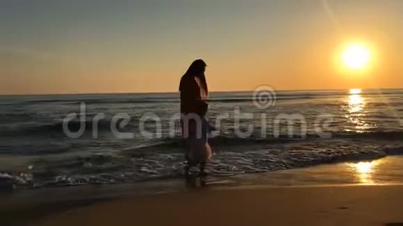 小女孩和年轻的女人沿着海滩散步视频的预览图