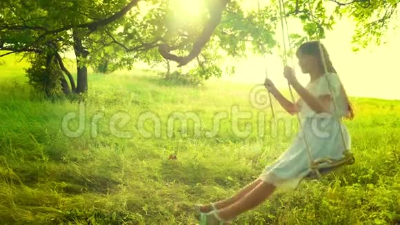 年轻的女孩在金色夕阳的眩光中摇摆着微笑着慢动作视频的预览图