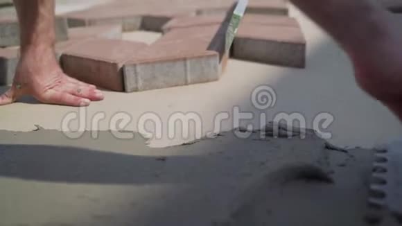 工人把胶水涂在路面上的瓷砖上视频的预览图