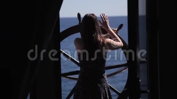 一个年轻的女孩站在酒店房间的露台上俯瞰大海视频的预览图