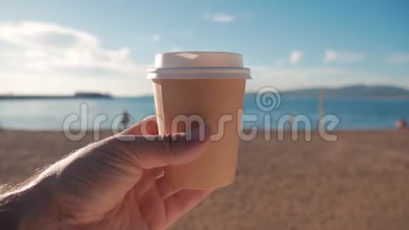 游客拿着一杯热咖啡靠在海滩和蓝海上旅游与旅游理念视频的预览图